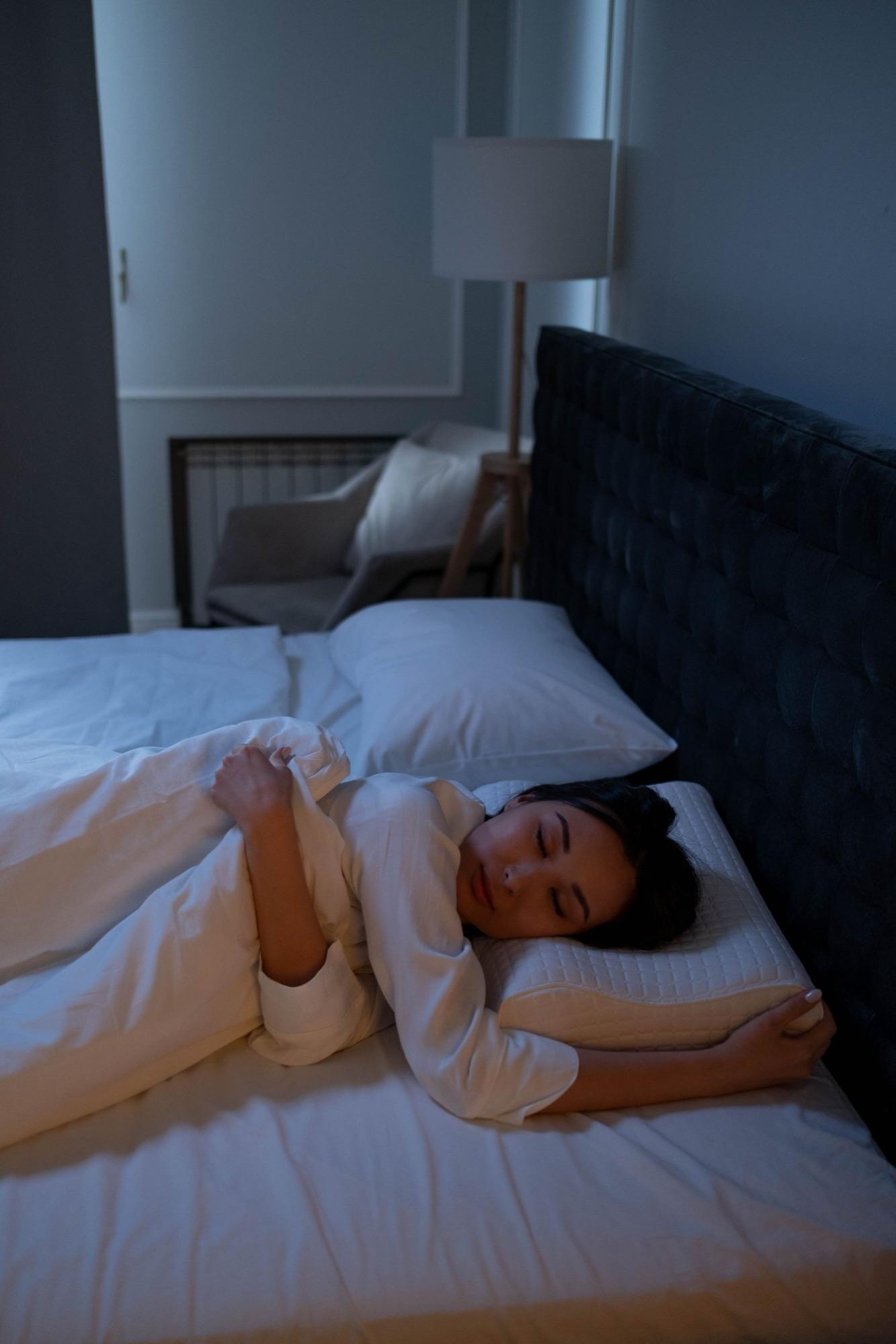 Person asleep in a dim, quiet bedroom