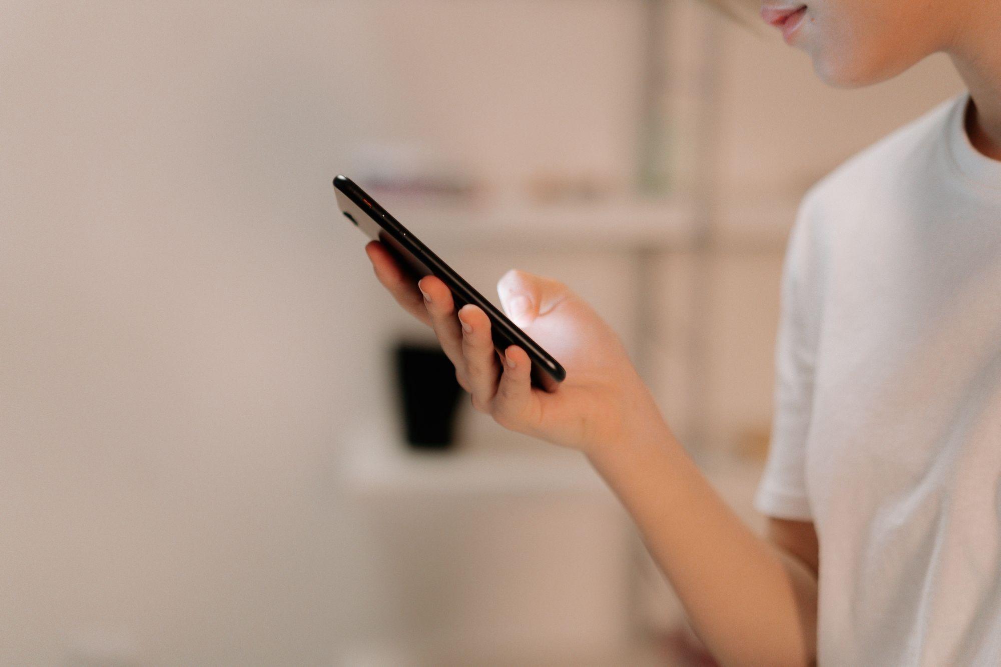 Close-up of a person reading a form on their phone at home