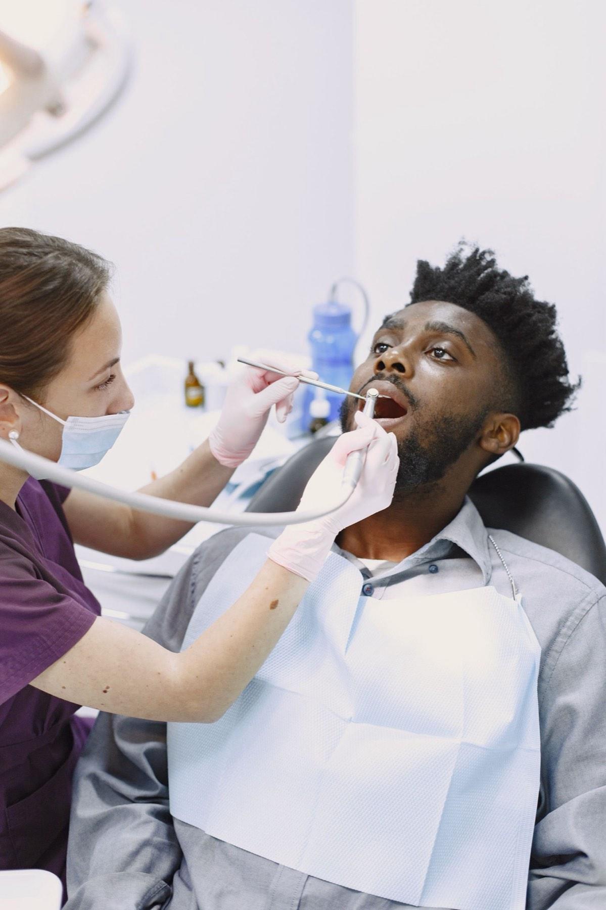 Dentist examining a patient in a bright operatory
