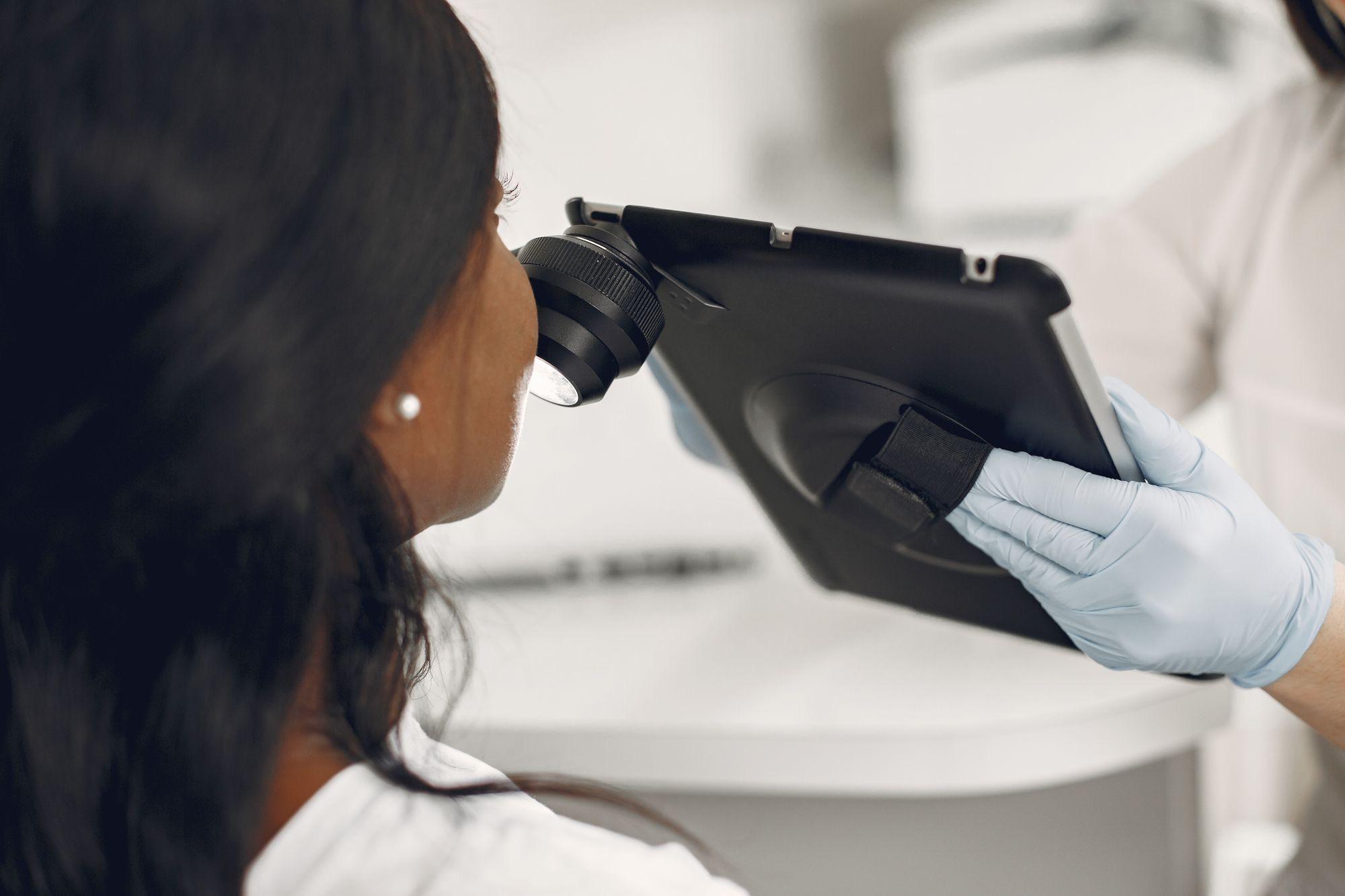 Dermatologist examining a patient's skin with a dermatoscope